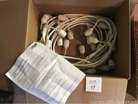 Box containing coiled 48 ft string of white sockets and a printed instruction sheet.