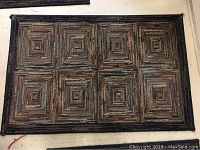 Photo of the smallest rug with geometric square spiral design in neutral colors.