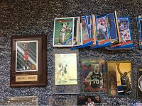 Photo showing Michael Jordan basketball plaque card along with multiple baseball and basketball cards.