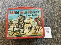 Front view of the vintage Wild Bill Hickok and Jingles metal lunchbox showing colorful western scene illustration and red border.