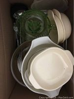Top view of box showing Corningware dishes, Pyrex glass juicer, beige mixing bowls