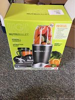 Box front view showing Nutribullet 12-piece set with 600 watt motor, BPA free, and contents.