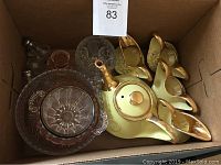 Box with yellow and gold porcelain teapot, four condiment dishes, and two clear cut glass bowls.