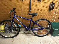 Blue Giant bike with 26-inch wheels against pegboard wall indoors.