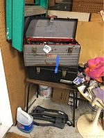 Two stacked metal tool boxes, top box (Craftsman) open showing tool contents, lower Benchmaster box closed.