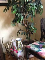 Photo showing two Asian vases, the faux ficus tree, and the brass nude sculpture grouped together near a wall and furniture