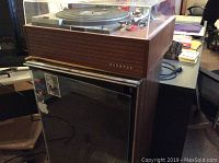 Full view of Pioneer turntable atop Sunwood wooden cabinet, adjacent items visible