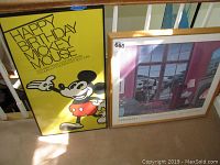 Two framed prints leaning against a stair railing