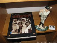 Cooperstown Hall of Fame Players hardcover book and Babe Ruth metal doorstop on wooden shelf