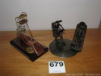 Three wire work sculpture figurines with psychoanalyst theme on wooden surface against white wall.