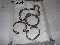 Full set laid flat in a box showing three bracelets and one necklace, twisted cable design with accent stones on ends