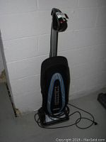 Front view of Oreck vacuum cleaner standing upright showing power cord and branding.