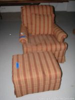 Striped upholstered rocking chair with matching ottoman on basement floor.