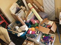 Wide view of craft lot showing lamp, yarn, bins, rolled posters, cutting mat