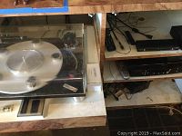 Audio-Linear turntable on shelf among other electronics