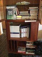 Wooden cabinet with multiple shelves containing assorted books