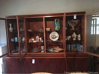 Full view of display cabinet with various crystal, ceramics, pottery, and Judaica items arranged on shelves.
