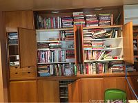 Wide shot of built-in wooden shelving filled with assorted books