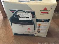 Original packaging box for Bissell Little Green portable deep cleaner showing branding, model features such as built-in heater and TurboBrush