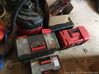Photo of three plastic tool boxes (black and red) and a Shop Vac hose in background