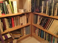 Bookshelves filled with multiple technical and programming books with various titles visible