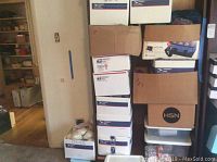 Multiple USPS and cardboard boxes stacked containing assorted skeins and balls of yarn