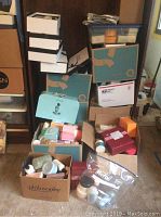 Boxes of assorted Philosophy, Perlier and Serious Skin Care products arranged on floor