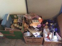 Two cardboard boxes filled with Perlier and L'Occitane items