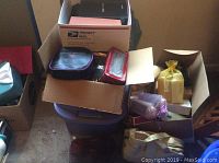 Wide view of several boxes and bags containing makeup and bath products on floor