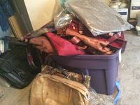 Purple plastic storage bin filled with assorted purses and totes