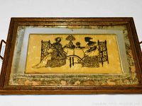 Full view of the rectangular antique Victorian tray showing metal frame with patina and artwork panel with two women at a table.