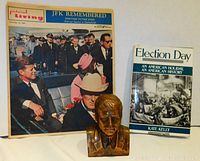 Photo showing vintage magazine 'JFK Remembered', book 'Election Day' by Kate Kelly, and bronze Kennedy bust.