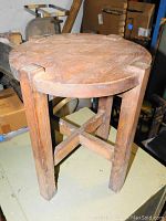 Front and top view of round wooden side table showing notched edge top and sturdy legs with cross supports.