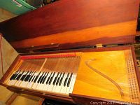 Top-down view with lid open showing entire keyboard and strings layout