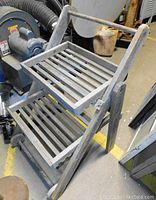 Two angled perspective photos of wooden 2-shelf plant stand showing foldable frame and slatted shelves