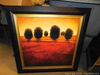 Front view of framed art showing tree silhouettes in warm tones with mocha and gold frame.