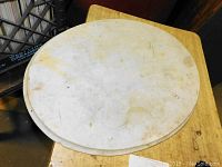 Top-down view of oval marble piece showing surface wear and natural veining.