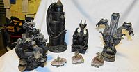 Full view of six dragon statues including three-headed dragon, castle tower dragon, seated dragon, two-headed candle holder, and two small dragon heads.