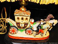 Close-up image of the ceramic Cinderella carriage lamp base featuring a horse and a driver figurine with detailed colors.