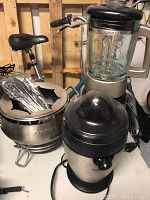 Wide shot showing all three Cuisinart kitchen appliances together: blender, juicer, and fondue pot.