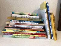 Side view of stacked children's books showing titles and varied thicknesses.