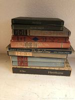 Side view of ten stacked vintage children's books showing titles and signs of wear.