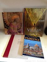 Four Italy art books displayed front cover visible, including one unopened Vatican Museums book and three other art/history books.
