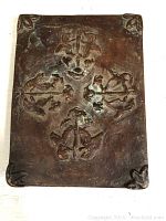 Full view of the cast iron hot plate showing central face, anchors and nautical motifs in relief.