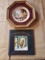 Photo of framed collectors plate titled "Storyteller" and autographed book "A Star for Christmas" together