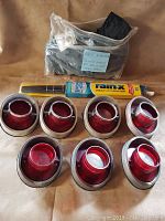 Front view of 7 round red Chevy Impala tail lights, Chevy Avalanche tie down straps in plastic bag, and 18 inch RainX wiper blades.