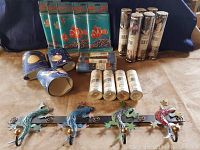 Overall lot photo showing multiple wallpaper border rolls and the metal lizard coat hook rack with four colorful lizards.