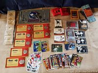 Wide view of the assorted sports cards, coins, and collectibles arranged on a dark surface.