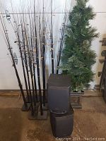View of entire lot showing two Aiwa speakers stacked, artificial potted Christmas tree and several dried flower stems in the background.