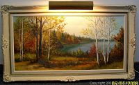 Full view of framed oil painting showing autumn landscape with birch trees and lake